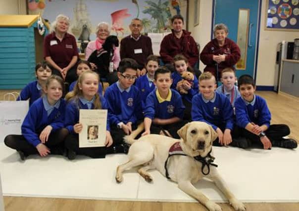 Hearing Dogs for the Deaf charity workers and people who use their dogs with children from River Beach Primary School who raised a lot of money independently.