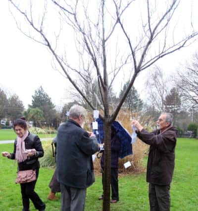 DM1612529a.jpg Holocaust Memorial Day commemorations, Beach House Park, Worthing. Tying messages to the Holocaust Memorial Tree. Photo by Derek Martin SUS-160127-130224008