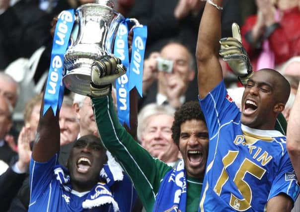 Sol Campebll lifts the FA Cup along with David James and Sylvain Distin