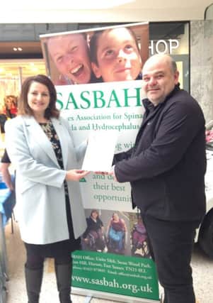 Rom Sanglaji, SASBAH chief executive, receives the letter from MP Caroline Ansell during a fundraising day at Eastbourne Arndale Centre SUS-160501-114716003