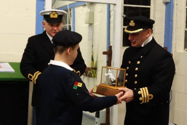 Tim Ash, executive officer of HMS Warrior, presents the Warrior Trophy