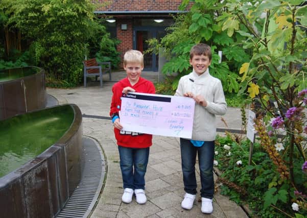 Connor, left, and Bradley deliver Â£45.26 to the hospice after their sponsored silence