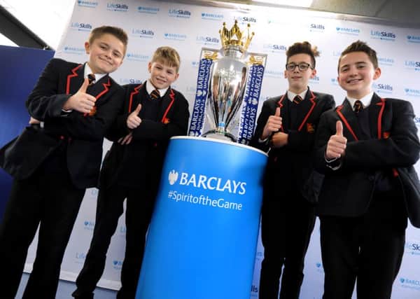 Year 9 pupils pose with the Barclays Premier League trophy at Ark William Parker Academy, Hastings. SUS-160302-155638001