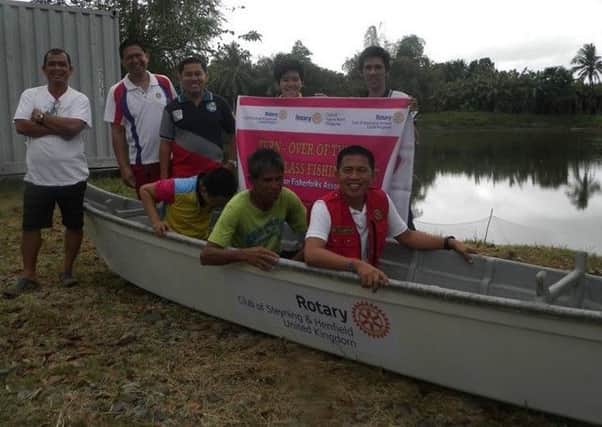 A small group of fishermen with their new boat in Tagum, which was seriously damaged by storms