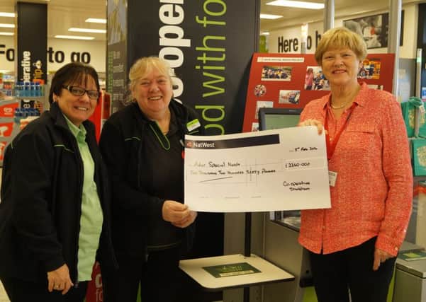 The Co-Operative team manager Sue Smith and Maggie Ford present the cheque to Adur Special Needs Project chairman Valerie Trevor