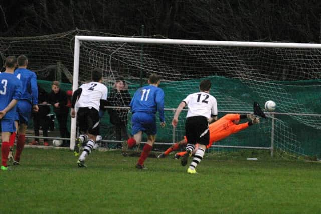 Horsham YMCA's keeper, Mark Fox saves shot from the penalty spot. Photo by Clive Turner