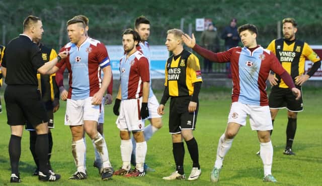 Players gather around the referee during Hastings United's 1-0 defeat at home to Three Bridges last weekend. Picture courtesy Joe Knight