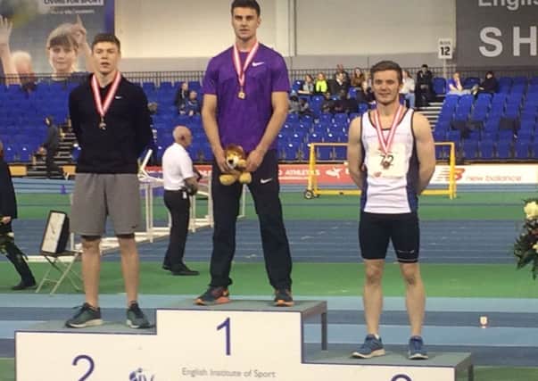 Tony Harries on the podium after his under-20 200m win