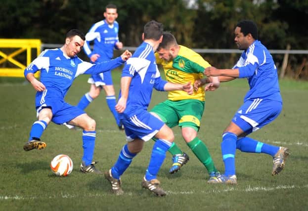 Westfield defender Martyn Durrant takes on a trio of Cowfold opponents. Picture by Justin Lycett (SUS-160227-160929002)