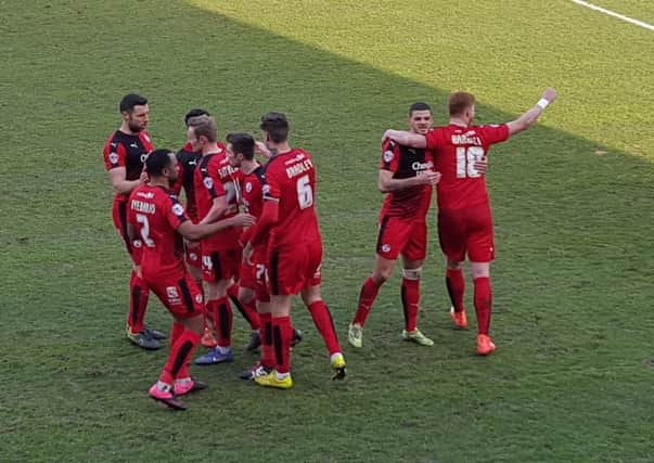 Crawley Town players celebrate Matt Harrold's goal in front of the West Stand.