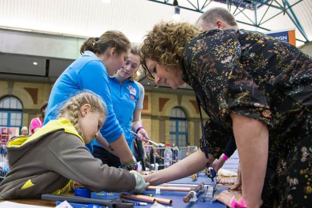 SGN Connections Designer Diane Jamieson helps a Brownie with the pipework activityat the Girlguiding Sparks event promoting  - picture submitted