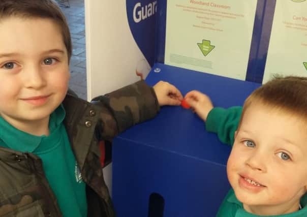 Five-year-old Liam Hathaway, left, and Davey Trott, four, putting their tokens in the Bersted Green Primary School box at Tesco in Bognor Regis