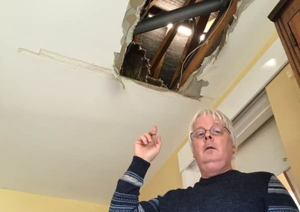 Hyde resident Andrew Wooldridge pointing to the hole in his lounge ceiling.
