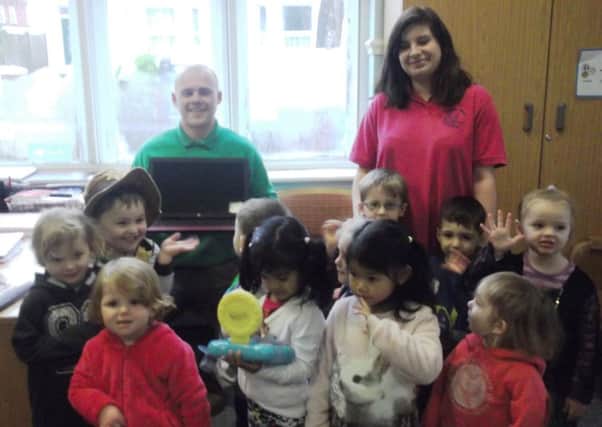 Ben Gillespie from PG Property Repairs and Renovations presents the laptop to Ashdown Road Playgroup