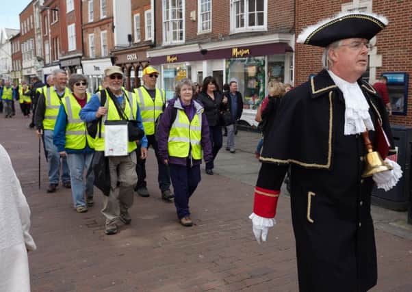 Chichester town crier Richard Plowman leads staff from Abbeyfield Chichester through the city centre