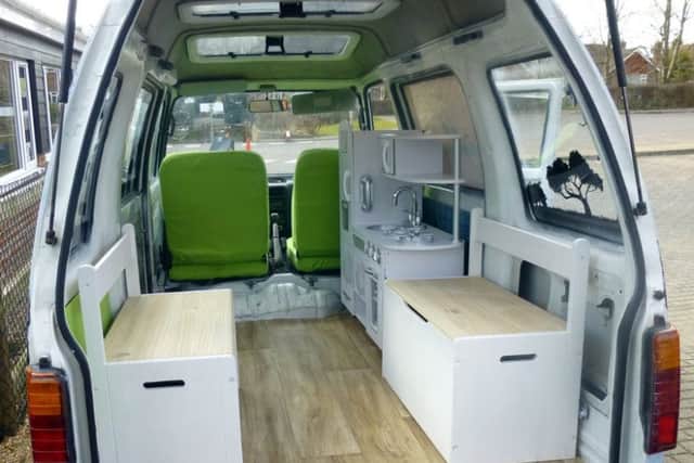 A work in progress - the new flooring, storage bench seats, new seat covers and play kitchen