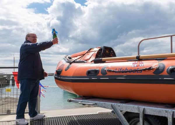 David Woodland, son of the late Joan Woodland, names the Shoreham inshore lifeboat and pours champagne over it.