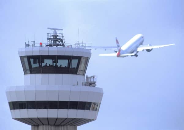 Gatwick Airport control tower with aircraft in flight in background SUS-150705-150051001