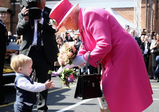 Little Charlie Capper, from Horley, hands over a posy to the Queen in Windsor yesterday.  PA Wire