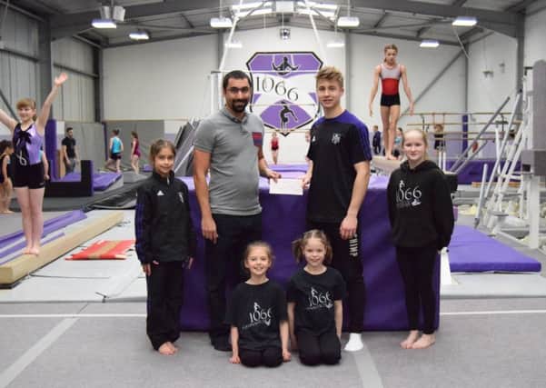 Rob Venkateswarlu of Sussex Police (left) presenting the cheque to  coach of 1066 Gymnastics club Callan Hall (right)