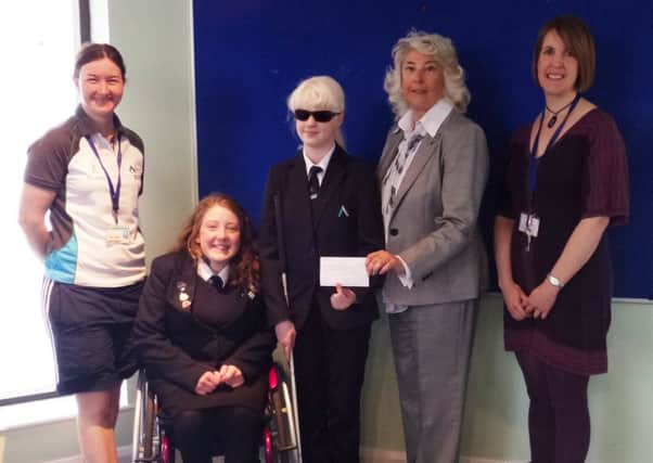 Catherine Mackenzie, trustee of The David Hunt Trust, presents a cheque for Â£5,700 to The Lavina Norfolk Centre