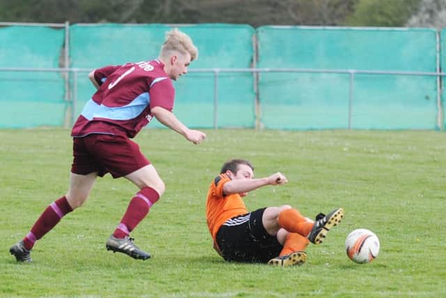 Little Common midfielder Cam Burgon tries to skip away from a Midhurst opponent. Picture courtesy Jon Smalldon