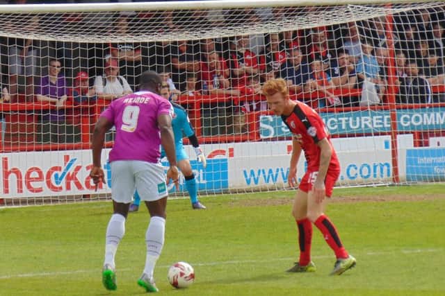Crawley v Barnet Bees' John Akinde takes on Reds defender Josh Yorwerth. Picture by Dylan Boorer SUS-160805-110258002
