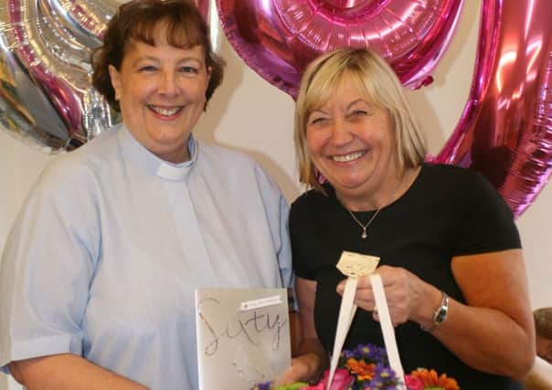 Jackie Moore, who manages Worth Park Playgroup based at Crawley United Reformed Church in Pound Hill celebrated her 60th birthday. Minister Rev Bridget Banks presented a card and flowers to Jackie - picture submitted by Crawley URC