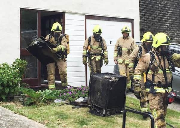 Fire crews removed the burnt out dishwasher from the building. Photo by Eddie Mitchell.