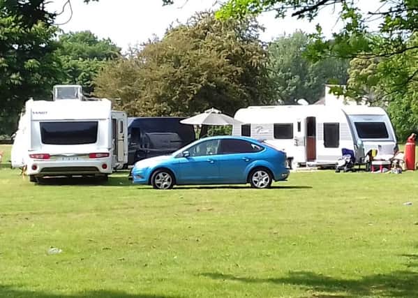 Two caravans and three other vehicles parked on the field next to Chichester College.