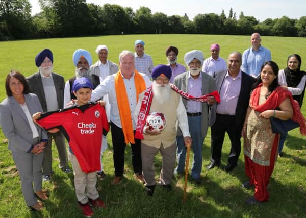Members of the Sikh community with Crawley Town Head Coach Dermot Drummy, assistant Matt Gray and Operations Director Kelly Derham at the launch of the partnership at the Sikh Gurdwara and Community Sports Centre in Ifield Green. Picture: James Boardman TPI-0293