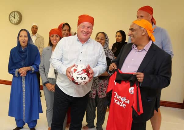 Members of the Sikh community with Crawley Town Head Coach Dermot Drummy, assistant Matt Gray and Operations Director Kelly Derham at the launch of the partnership at the Sikh Gurdwara and Community Sports Centre in Ifield Green. Picture: James Boardman TPI-0293