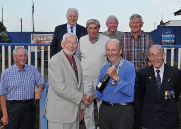 Harry Treadwell, front left in grey suit wearing glasses, being presented with champagne by John Colwill watched by other members of the 41 Club to mark 50 years of membership.