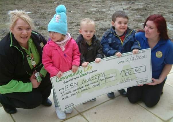 ASDA Community Champion Wendy Border presents one of the cheques to St Nick's nursery SUS-160615-093020001