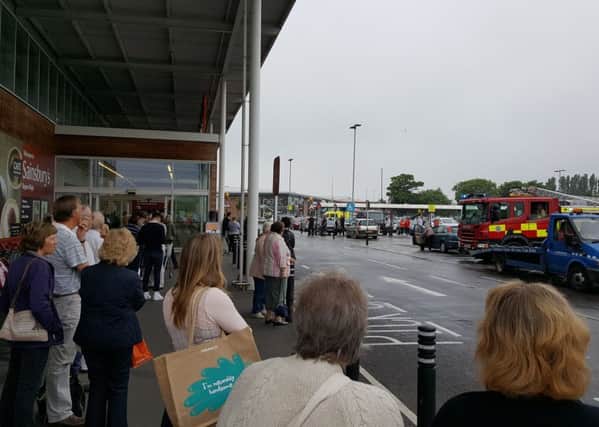 Shoppers waiting outside the store as firefighters investigated. Picture supplied by Graham Partin