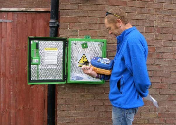 Paul, a Sompting Big Local Volunteer, carrying out the fortnightly Guardian check on the new defibrillator on the western wall of St Peters Church, Bowness Avenue, before reporting back to Heartsafe/SECAMB.