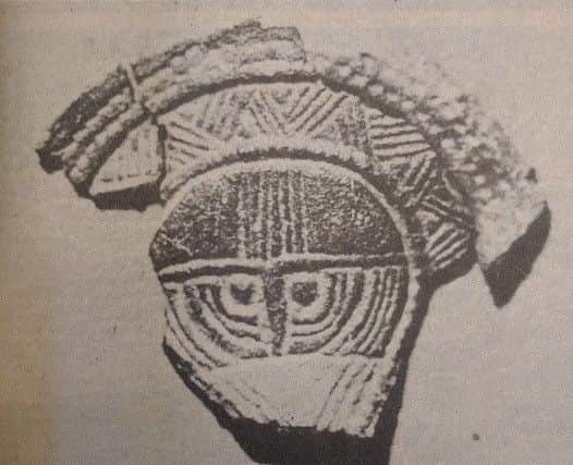 A bronze face mount which was found in one of the seventh century graves at East Marden