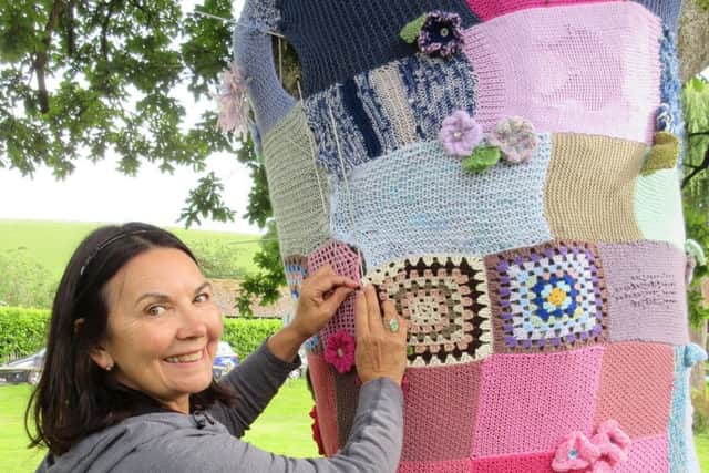 Larrie Robinson puts the final stitch in place to complete the  artistic creations