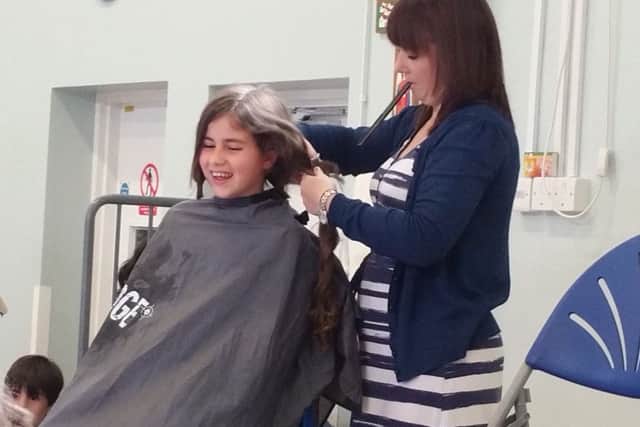 Laura Molina-Rivas having her hair cut