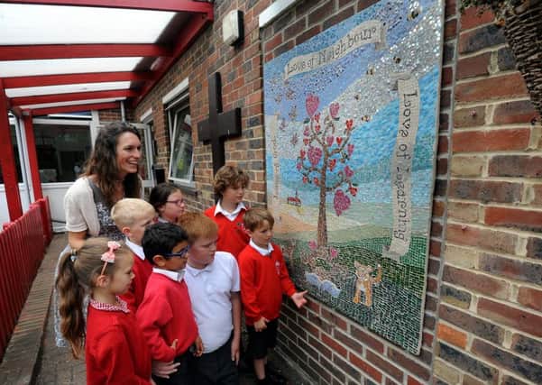 Arundel Church of England Primary School pupils admiring their mural with artist Rosie Hewitt. Pictures: Kate Shemilt ks16000853-1