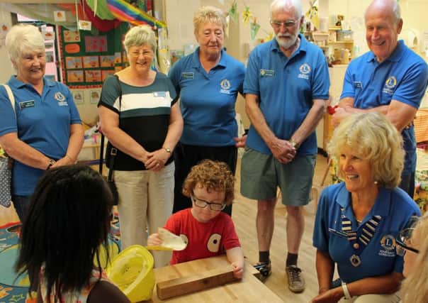 Adur East Lions members visit Fishersgate Nursery to see how children are using the equipment bought with funds they provided
