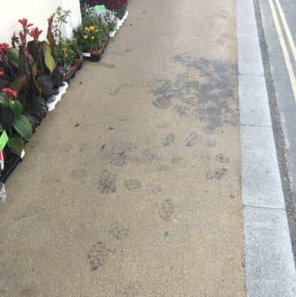 The paving is covered in oil and footprints
