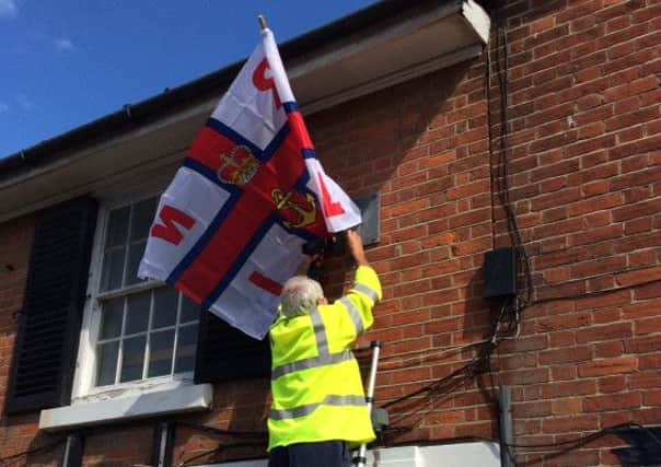 Chairman of Selsey Town Council, Mike Beal, helping out with an RNLI flag for Lifeboat Week.
