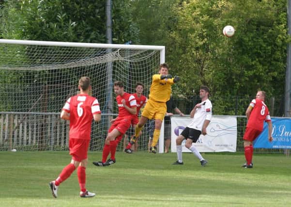 Horsham YMCA keeper Mark Fox clears Horsham attempt in their pre-season friendly on Saturday. Photo by Clive Turner