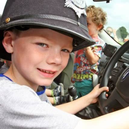 Alfie Scurr-Osborne, seven, behind the wheel of a police car DM16132486a