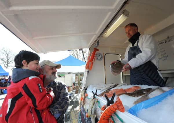 C150037-24 Chi Chichester Market  phot kate

Engleberty Reileanu with Andreas, six, and Tony Bailey from Shoreline Fish.Picture by Kate Shemilt.C150037-24 SUS-150223-165539001