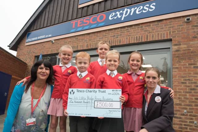 Isabelle Fowlie, Louis Wild, Anthony Fowlie, Freya Delves, and Hattie Morton-Davagh from Ark Little Ridge Primary Academy open the store and teaching assistant Sandra Christie receives a Â£500 cheque from store manager Sarah Lee. SUS-161208-112754001