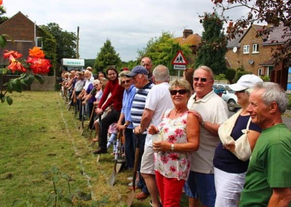 Villagers line up along the proposed route of the drain system at a protest at the recreation ground on Saturday