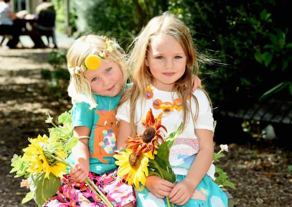 Isla Thompson, three,  and Mia Thompson, five,  with their prize winning vegetable necklaces and flowers