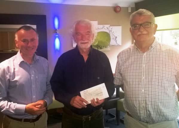 Neil Holloway, the Bognor Regis club secretary, left, and Mike Turner, the Littlehampton club president, right, present cheques to Roger Bacon from Chichester PCaSO Prostate Cancer Network